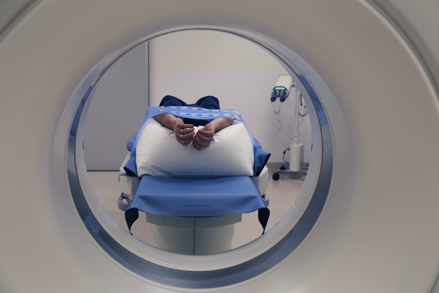 Ein Patient ist positioniert auf der Liege eines CT Scanners