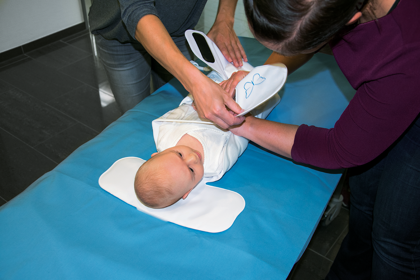 Newborn getting wrapped in BabyFix Cocoon to get ready for MRI