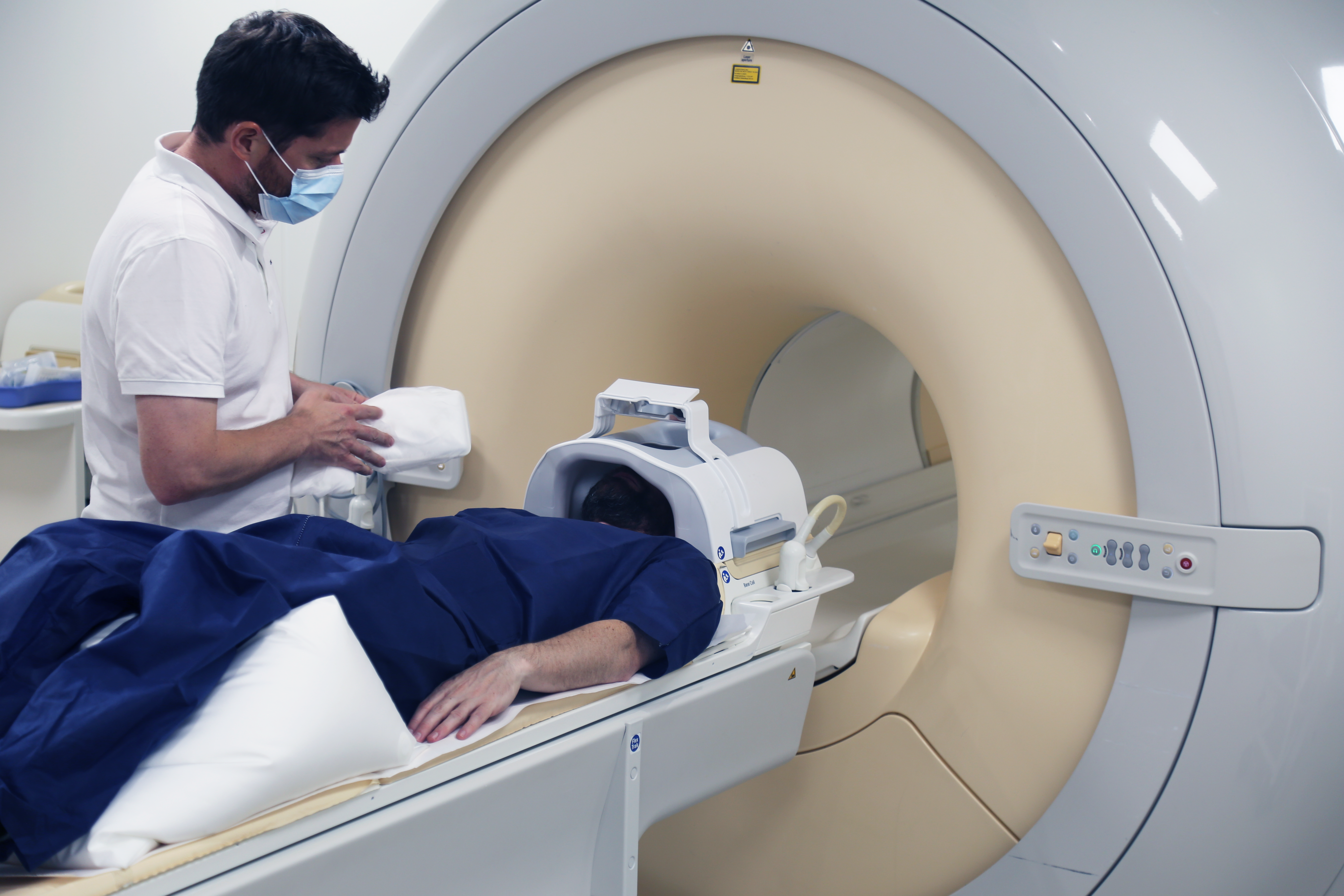Patient wird von Radiologiefachperson im CT immobilisiert